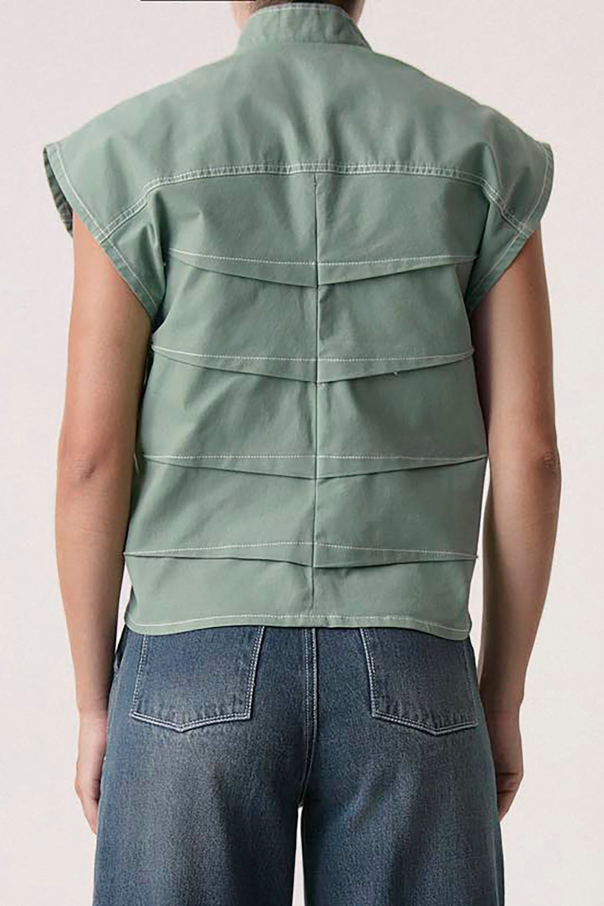 The Bardi Vest in matcha green, back view with pleated panels — Sanna, The Gentlewoman collection